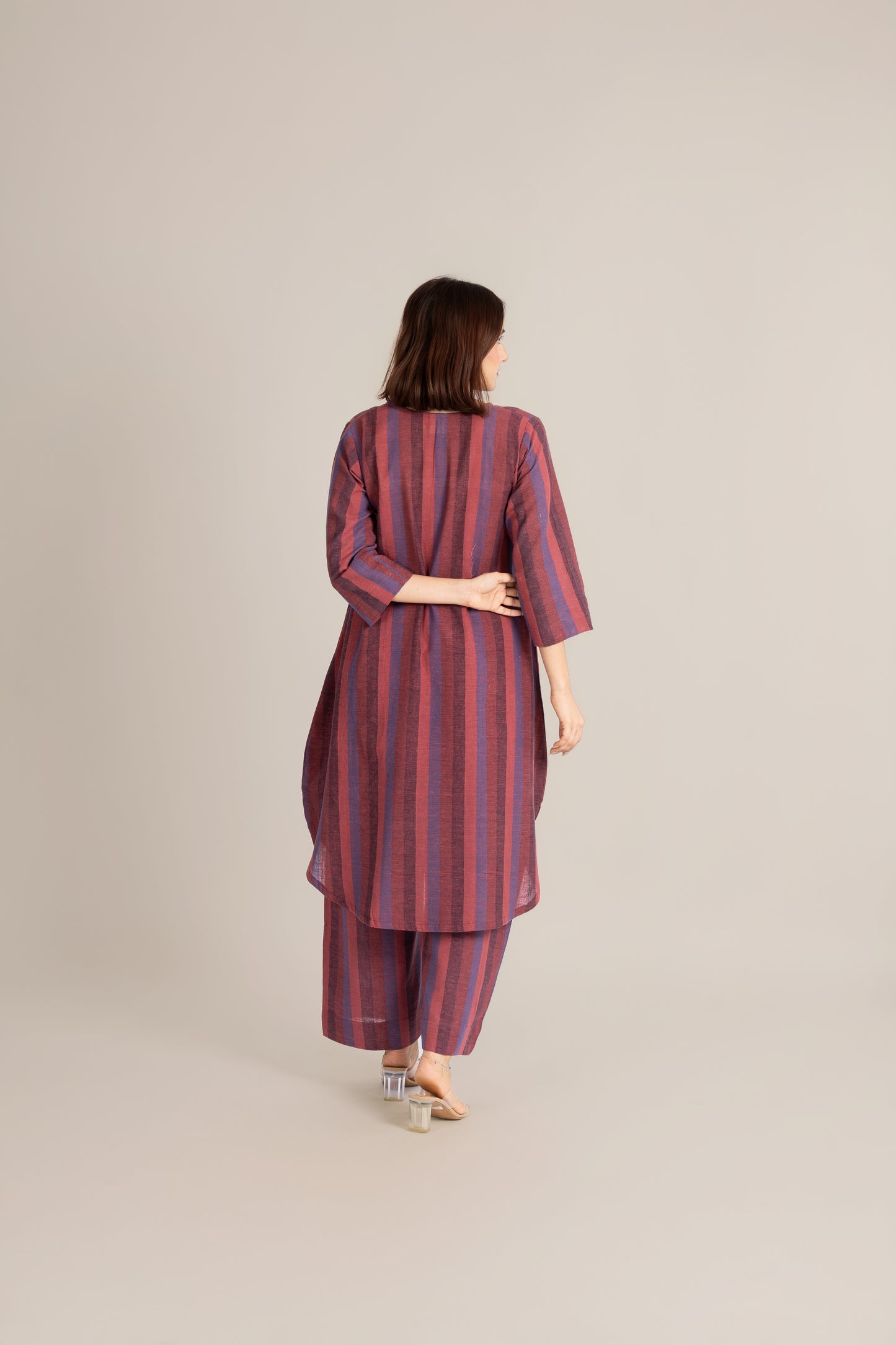 Woman wearing a striped outfit on a beige background