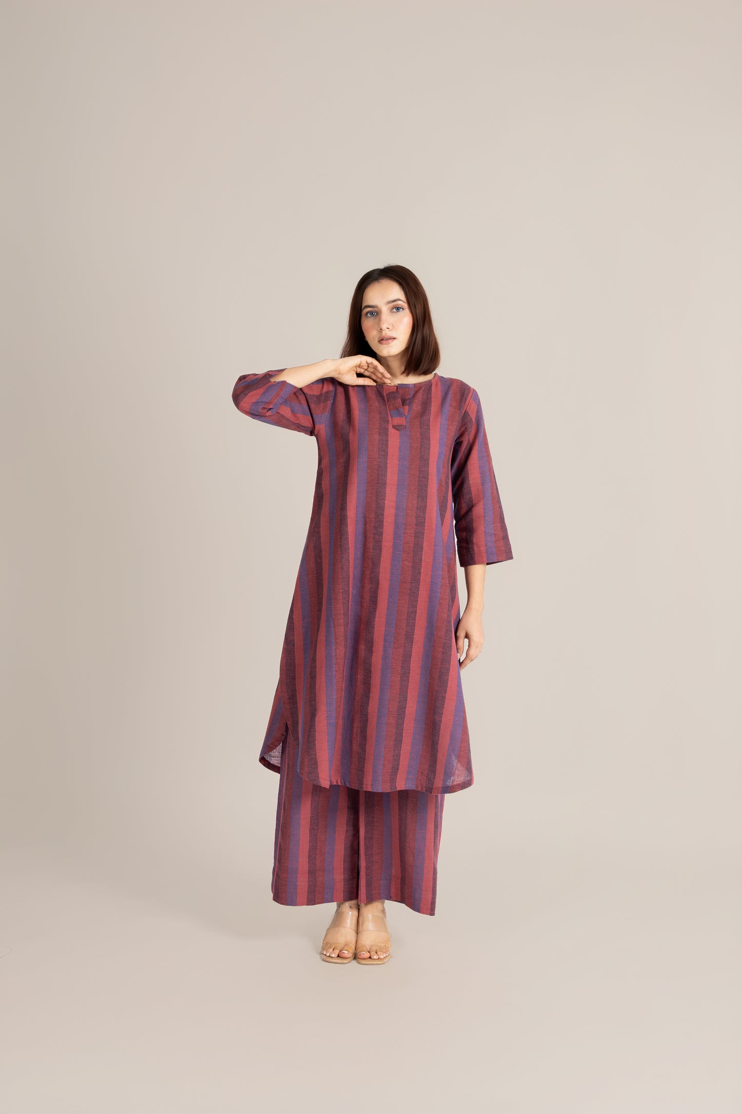 Woman wearing a striped dress on a plain background