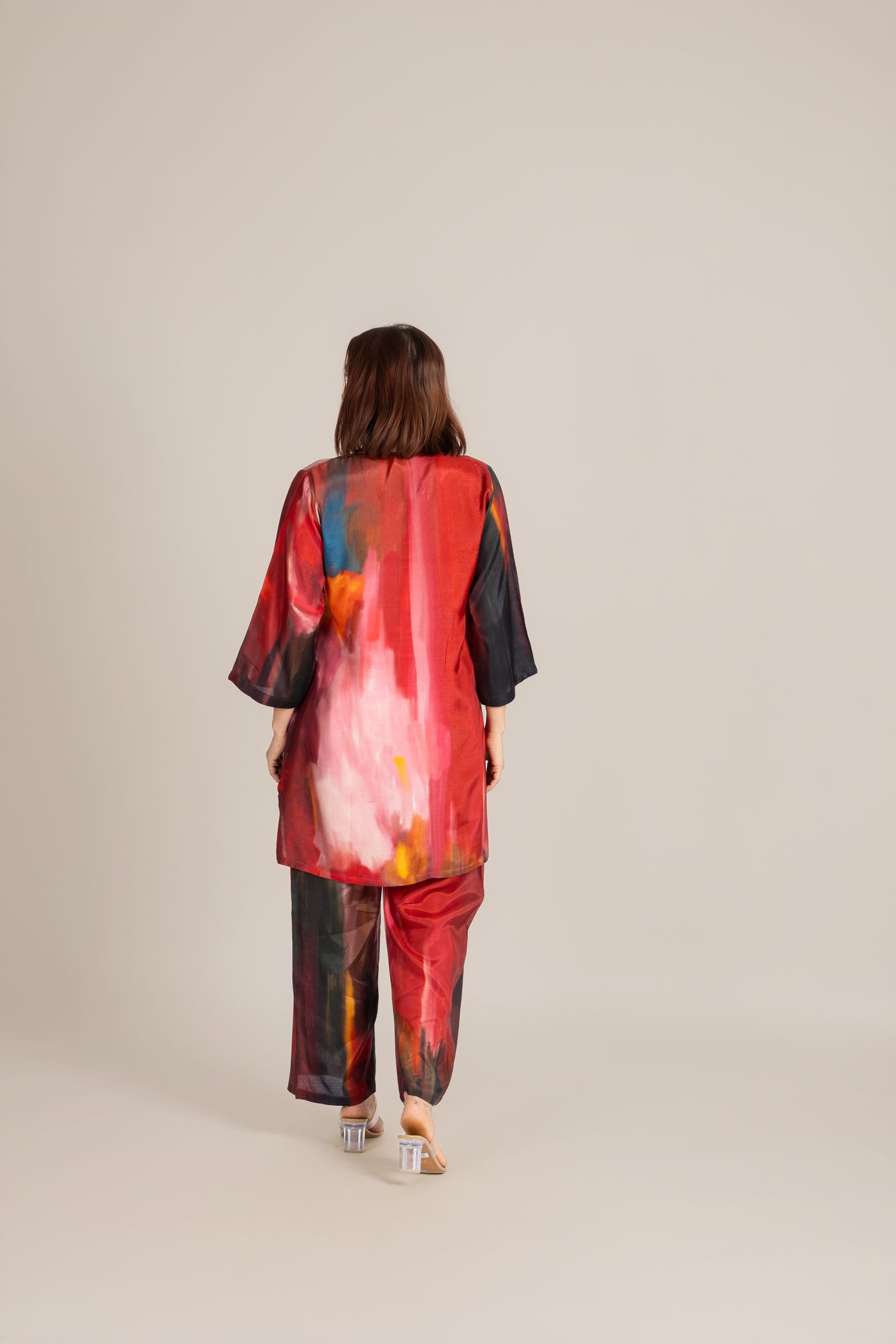Woman wearing a colorful outfit with abstract patterns on a beige background