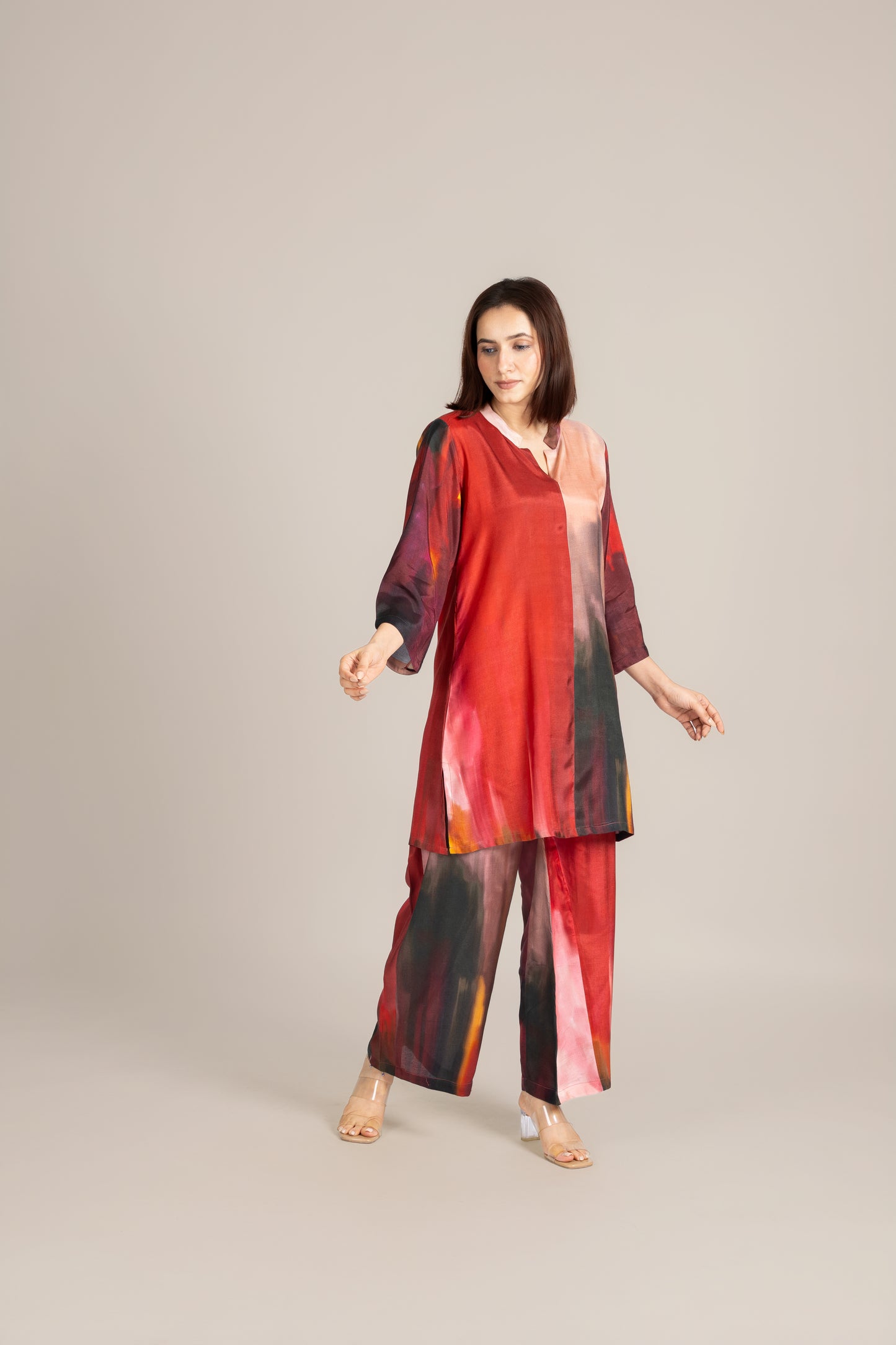 Woman wearing a red and black patterned outfit on a beige background