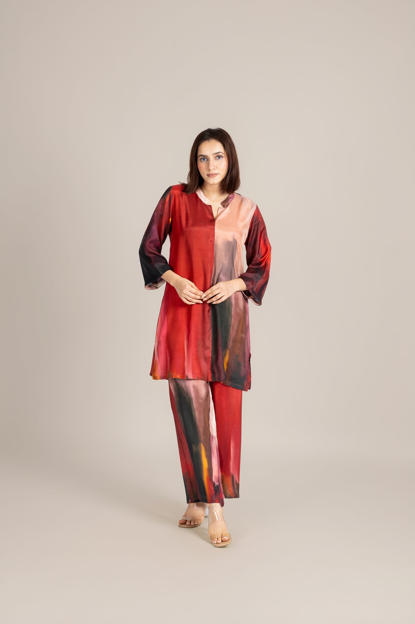 Woman wearing a red and black patterned outfit on a beige background