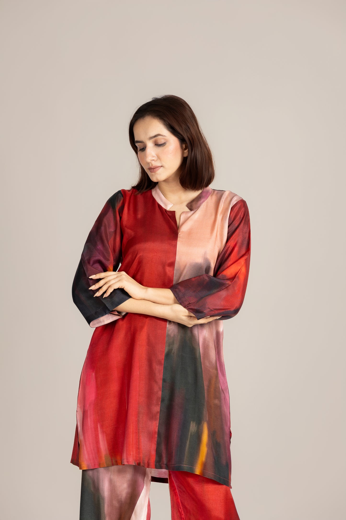 Woman wearing a red and black patterned outfit on a beige background
