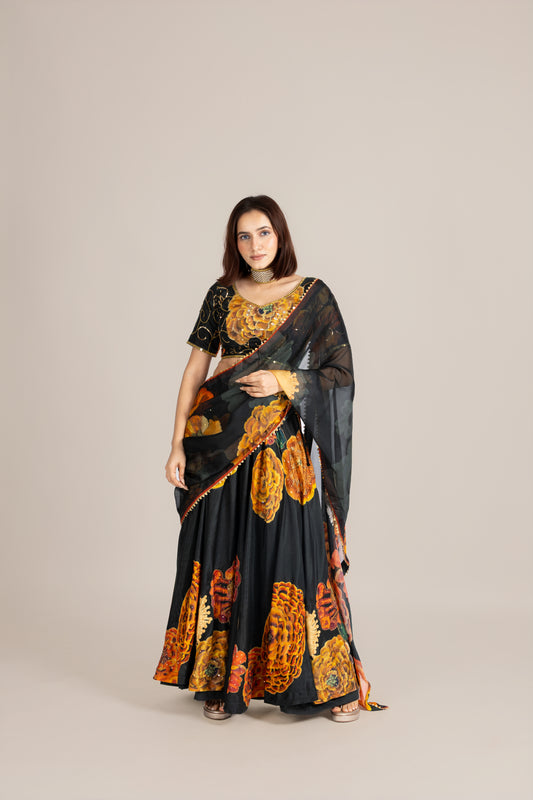 Green marigold lehenga Woman wearing a black saree with floral patterns on a beige background