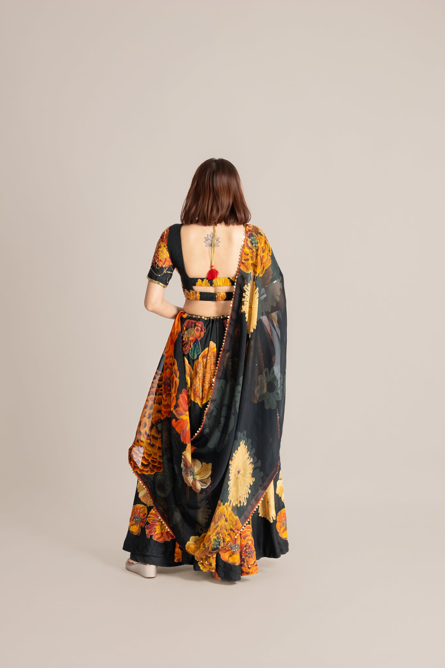 Woman wearing a colorful saree with a neutral background