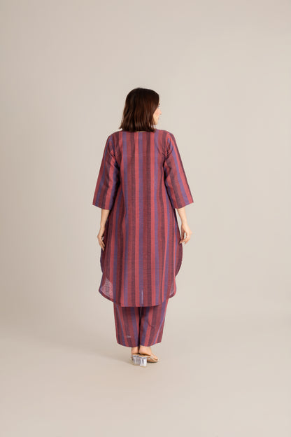 Woman wearing a red and purple striped outfit on a beige background