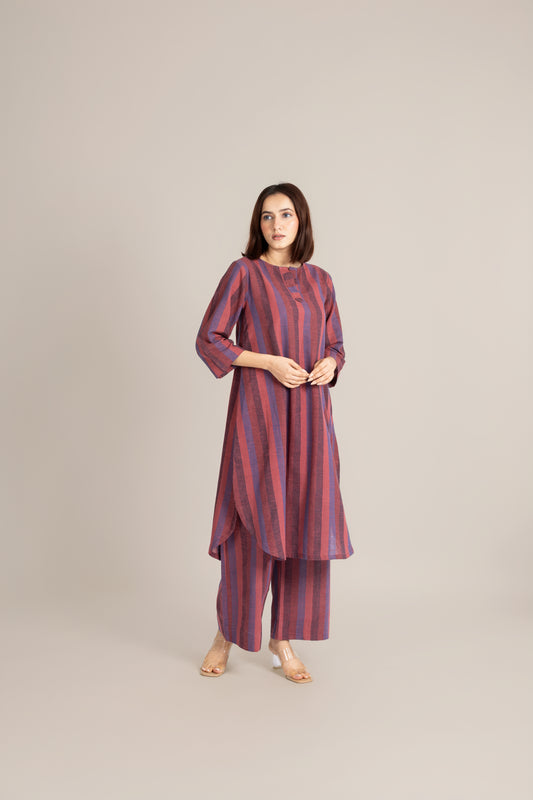 Woman wearing a striped kurta with pants on a beige background