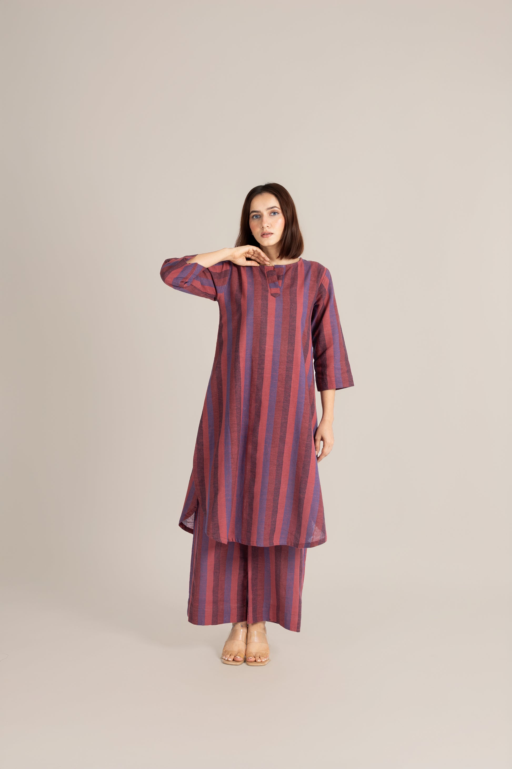 Woman wearing a striped dress on a plain background