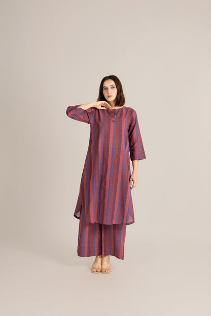 Woman wearing a striped dress on a plain background
