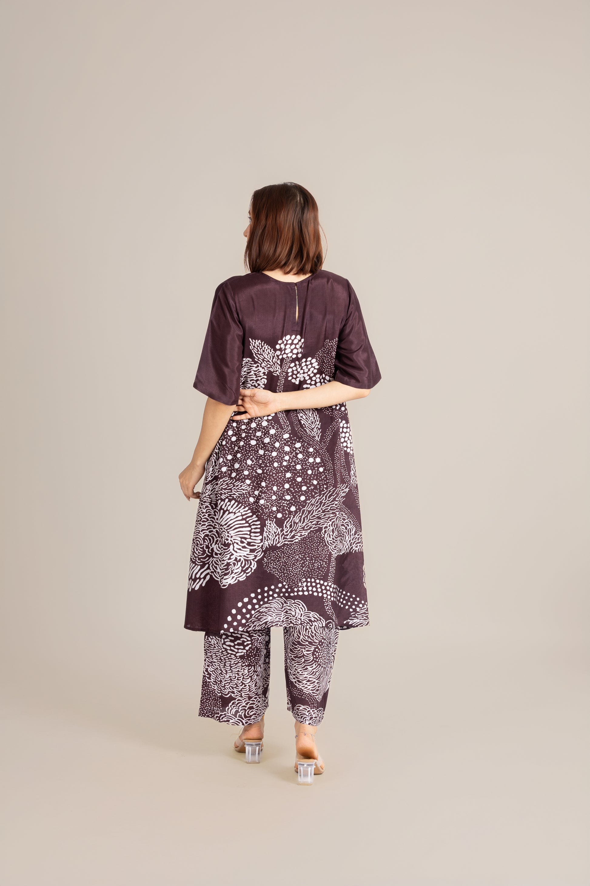 Woman wearing a patterned outfit on a plain background