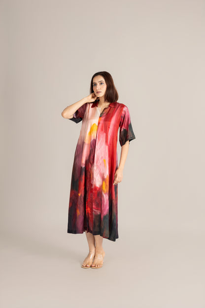Woman wearing a colorful dress with abstract patterns on a plain background