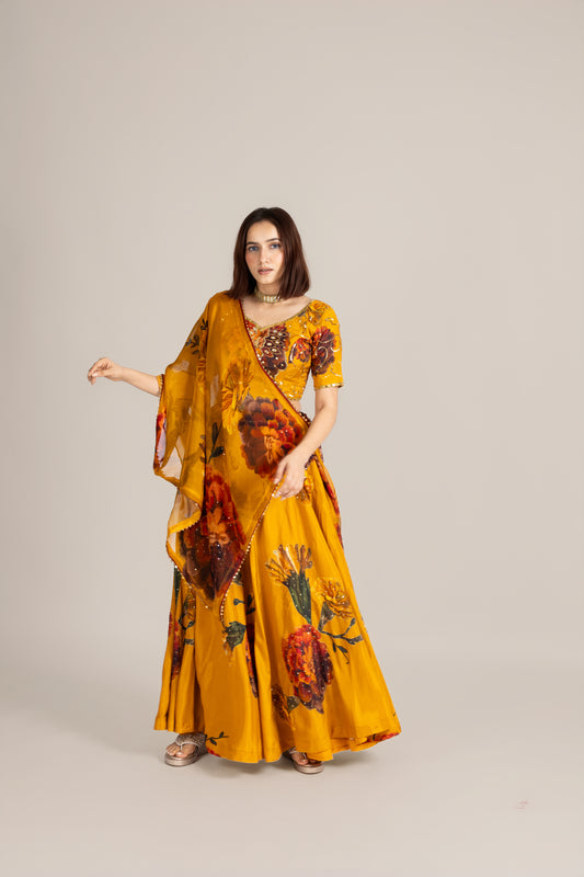 Woman wearing a yellow floral saree against a plain background