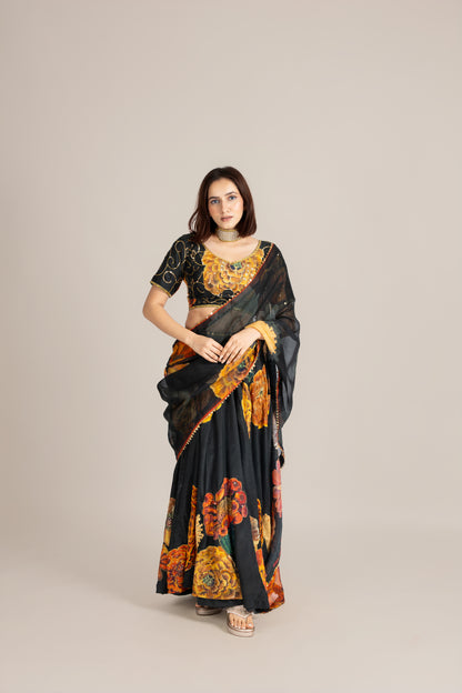 Woman wearing a black saree with floral patterns on a beige background