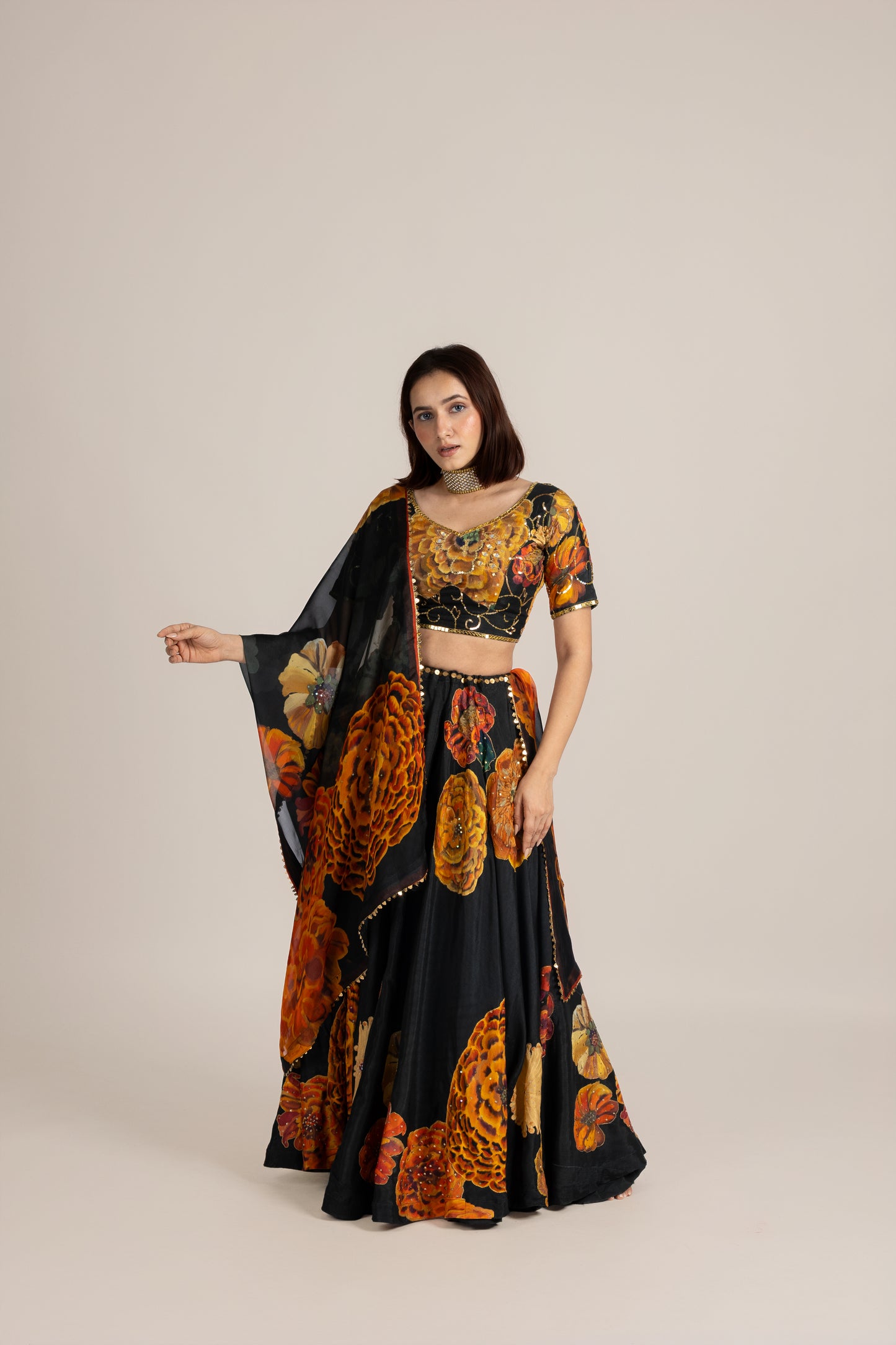 Woman wearing a floral and black outfit on a beige background