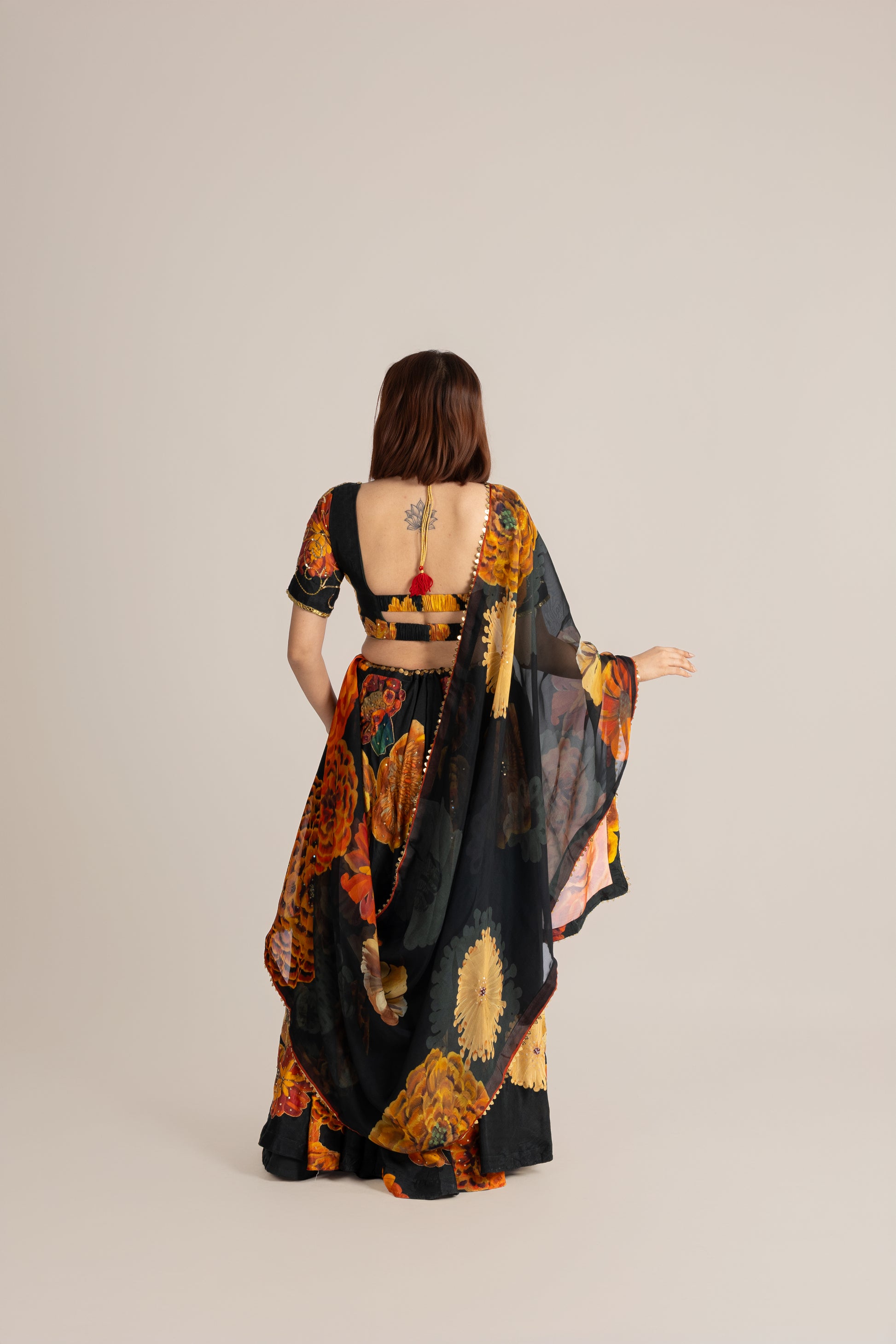 Woman wearing a colorful, patterned outfit with a neutral background